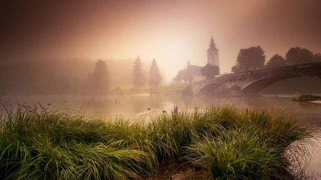 Majestic colorful foggy scene on the lake in Triglav national park, located in the Bohinj Valley. Time lapse clip.