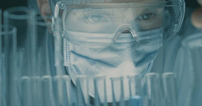 In a laboratory, a scientist with a pipette analyzes a liquid to extract the DNA and molecules in the test tubes.Concept:research,biochemistry,immersive technology,augmented reality