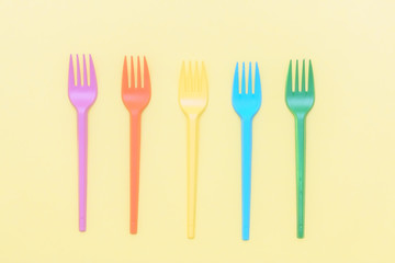 colorful forks on yellow background