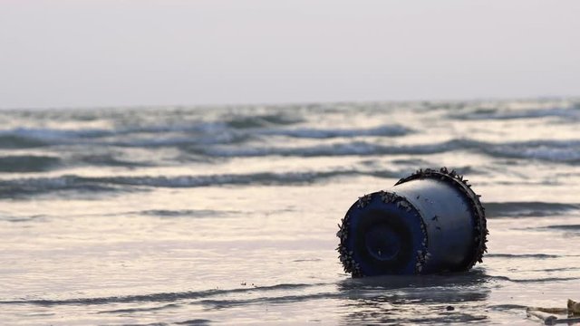 Sandy beach with waves rippling to the shore. Loaded with rubbish on the beach, it is polluted by the sea. Cause the sea to fall. Change environment Show emotion, loneliness and despair.