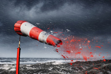 Damaged windsock and stormy sea - storm warning