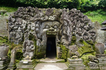 Entrance of cave through carved mouth wide open in Bali Indonesia