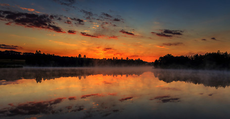 Fototapeta na wymiar wonderful misty morning. majestic sunrise over the lake. picturesque dramatic scene.