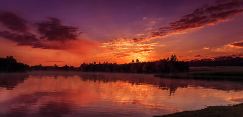 wonderful misty morning. majestic red sunrise over the foggy lake