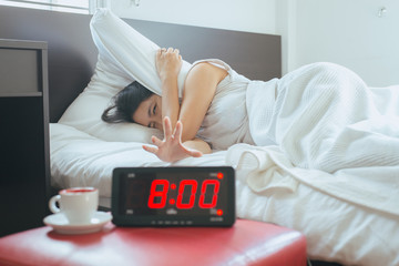 Asian woman hates getting stressed waking up early 8 o'clock,Alarm clock
