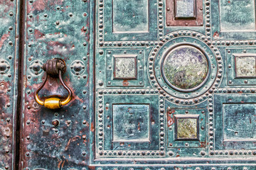 old knocker at a metal door