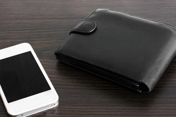 Leather wallet and mobile phone on a wooden surface. Leather. Money wallet.