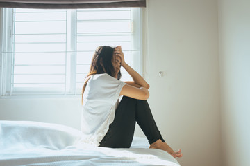Asian woman have a headache on bed after wake up in the morning