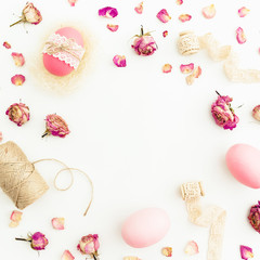 Round frame of Easter pink eggs with twine, roses flowers and tapes on white background, Top view, Fat lay. Easter holiday