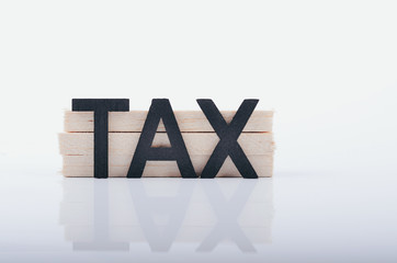 TAX word and reflection on white surface