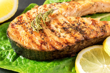 Salmon fillet. Grilled salmon with herb and lemon on black slate board.
