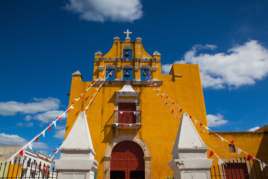 Yellow colonial church with a deep blue sky in Campeche, Mexico.