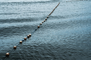 Line of white saferty buoy on seascape. Concept of lifeguard details in ocean