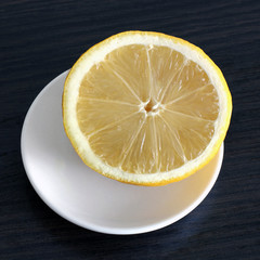 Lemon on a plate on a wooden background. Fruit