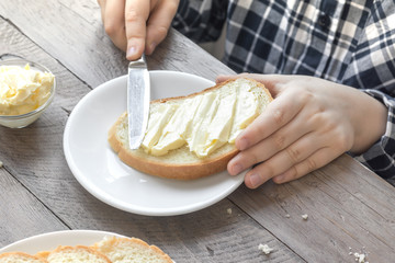 hands spreading butter on bread