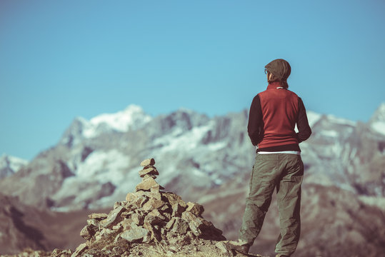 Hiker on mountain top looking at panoramic view, Massif des Ecrins National Park, the european Alps, vintage toned image, rear view, old retro style.
