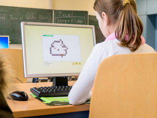 Kind sitzt in der Schule am Computer