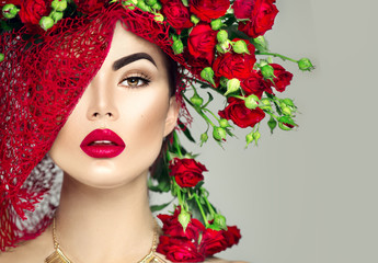 Beauty model girl with red roses flower wreath and fashion makeup. Flowers hairstyle