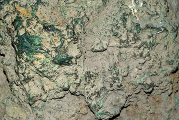 background, texture - surface of an unprocessed block of malachite with patches of green stone