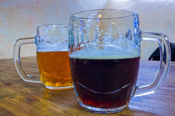 The two glasses of czech beer on a wooden barrel table