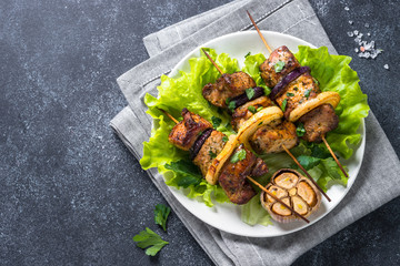 Grilled shish kebab or shashlik on black stone table top view.