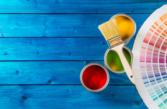 Paint Cans Color Palette, Cans Opened With Brushes On Blue Table