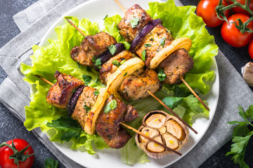 Grilled shish kebab or shashlik on black stone table.