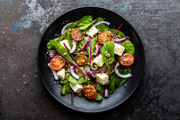 plate of nutritious simple salad with chard, walnuts, soft cheese, onions and oil, top view, space for text