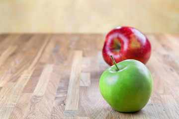 two ripe juicy apples lying on an oak table
