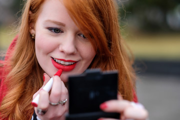 Redhead Putting On Lipstick