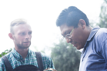 Two serious men rasists - caucasian man and native american.