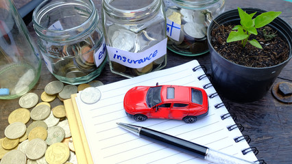 Toy car and Money coins in glass bottles on hand.insurance money savings, retirement planning ,travel and investment ideas, passive income and finance