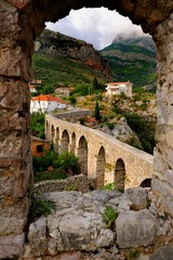 Fototapeta premium Bar, Montenegro, view of aqueduct in Stari Bar through stone window in fort wall 