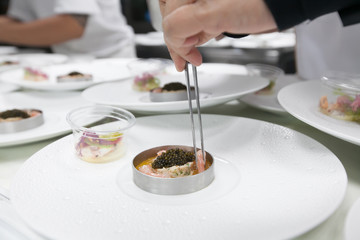 Chef cooking food with Caviar and shrimp for dinner party in the restaurant kitchen.