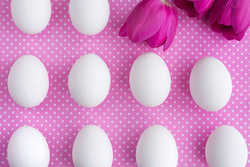 White eggs and pink flowers on polka dot fabric