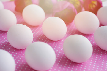 White eggs and pink flowers on polka dot fabric