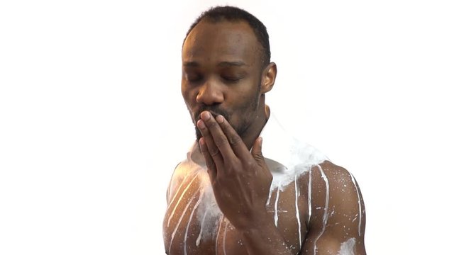 Bearded black man sends an air kiss and winks, greeting card. Slow motion shooting