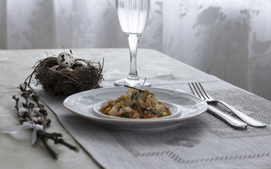 on a table napkin with a plate vegetable stew green onion glass fork knife and willow branches with a quail eggs salt pepper