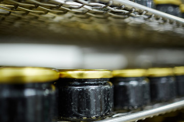 Black caviar canned in small jars standing in row on one of supermarket shelves