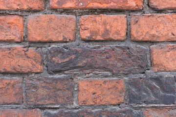 Fototapeta premium Close up of weathered vintage red and brown brick wall of an old factory building, some bricks are dirty, copy space, horizontal/ Grunge architecture/ Bricks are damaged by time