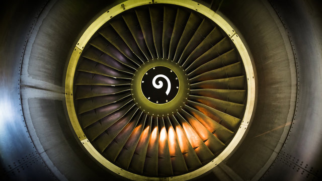Close up of fan engine and turbine blades of modern civil passenger airplane illuminated beautiful light, front view/ Technology, aircraft construction, aviation concept/ Aircraft engine maintenance