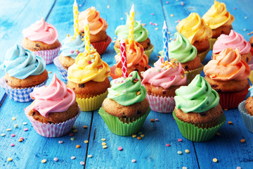 Tasty cupcakes on wooden background. Birthday cupcake in rainbow colors