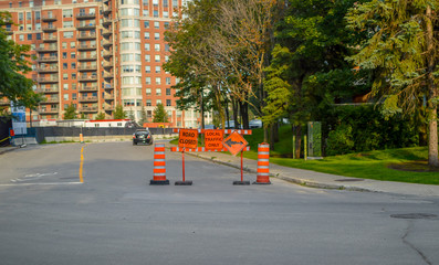 The cones,  road closed and local traffic only orange signs on the sidewalk in Montreal, Canada