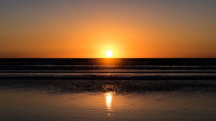 Sun setting low over a shimmering ocean