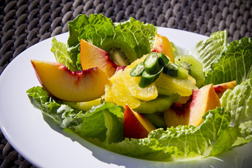 Vibrant summer salad with juicy peach slices and fresh greens, styled for a wholesome, plant-based culinary concept.