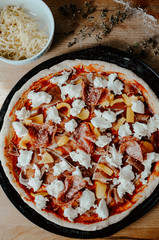 Pizza dough with pepperoni salami, mozzarella and bell pepper ready to be baked in oven. View from above.