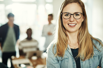 Young businesswoman smiling with colleagues working in the background