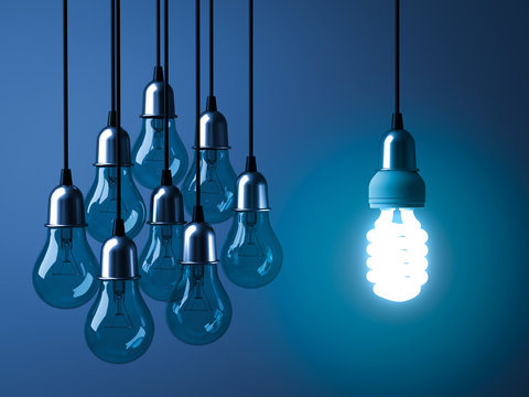 One hanging eco energy saving light bulb glowing and standing out from unlit incandescent bulbs on dark blue background , leadership and different creative idea concept. 3D rendering.