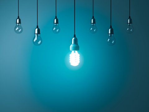 One hanging energy saving light bulb glowing stand out from unlit incandescent bulbs with reflection on dark cyan background , leadership and different creative idea concept. 3D rendering.