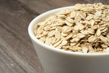 Avena cruda o copos sobre fondo de madera